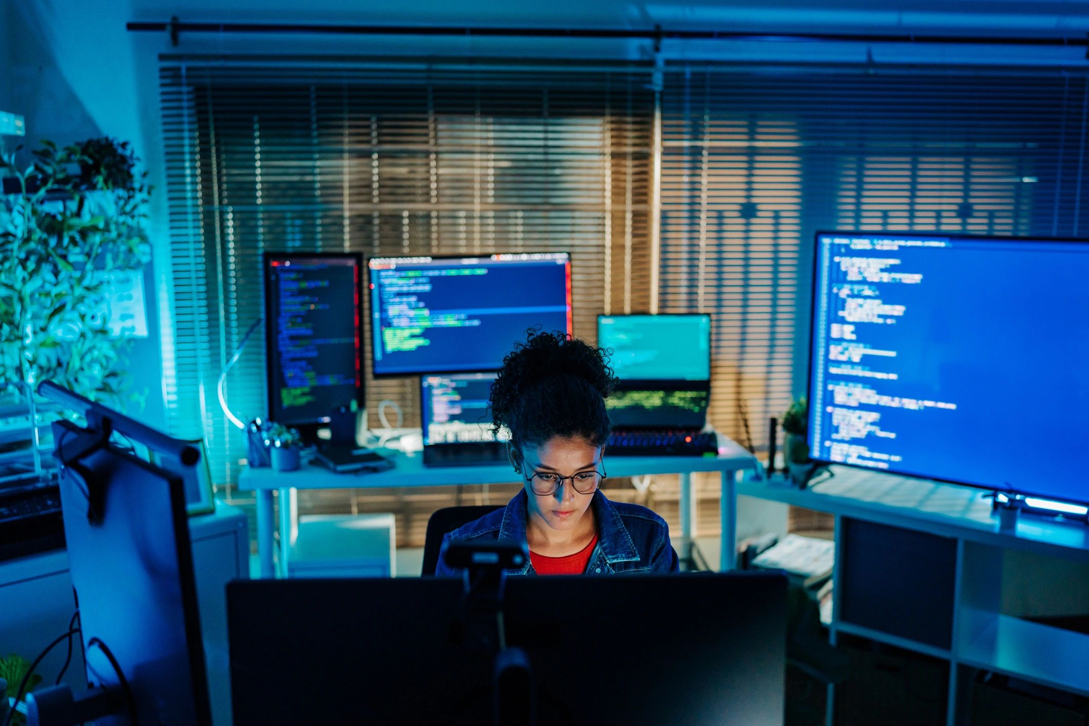 Profesional de tecnología trabajando en una estación con varios monitores